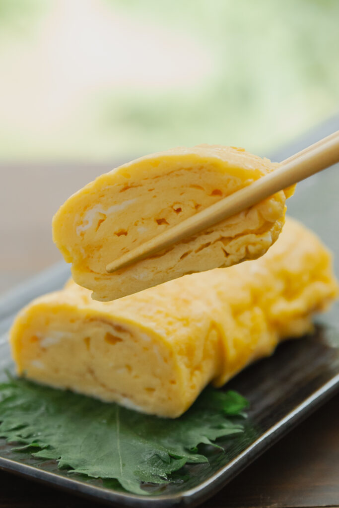 Homemade sweet and savory Japanese tamagoyaki rolled omelet sliced on a plate