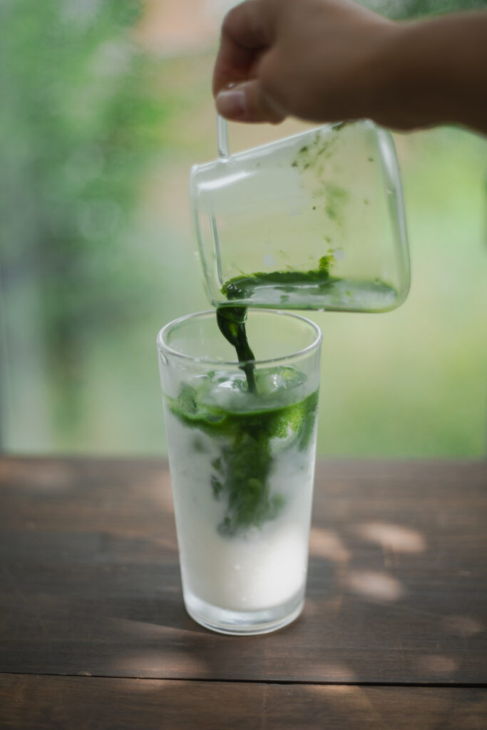 Homemade authentic Japanese iced matcha latte with a beautiful green and white marble layer in a tall glass