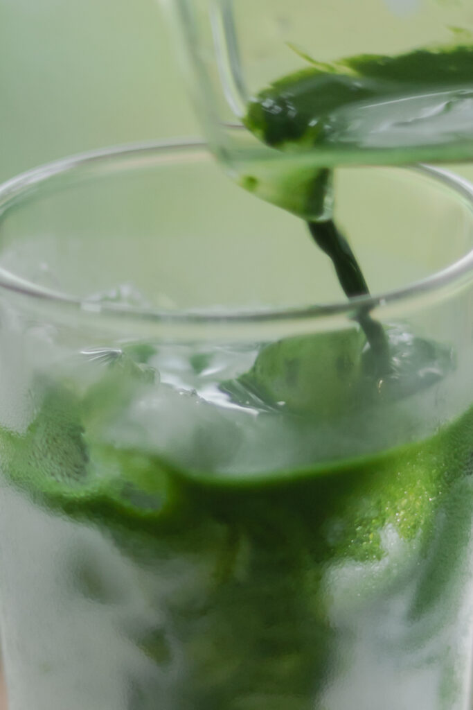 Homemade authentic Japanese iced matcha latte with a beautiful green and white marble layer in a tall glass
