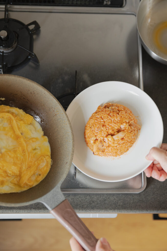 Homemade Japanese omurice chicken rice bowl topped with a fluffy runny omelet and ketchup