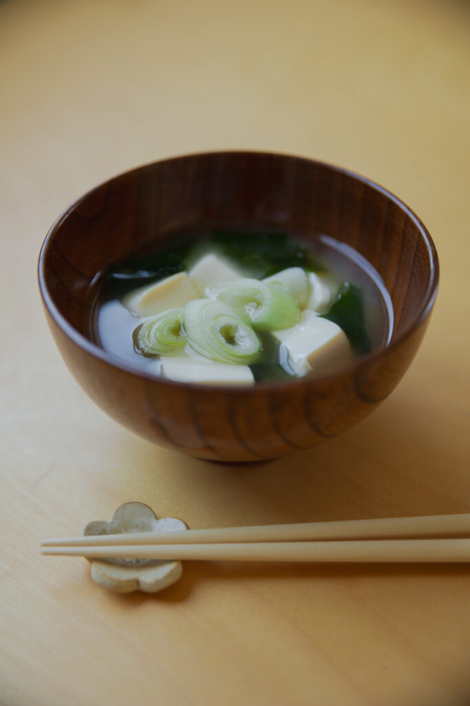 Homemade Japanese miso soup with tofu and green onions in a wooden bowl