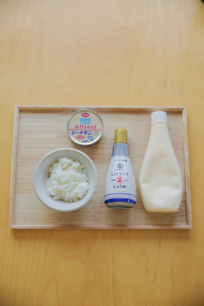 Four types of Japanese onigiri rice balls including salmon and tuna mayo on a bamboo basket