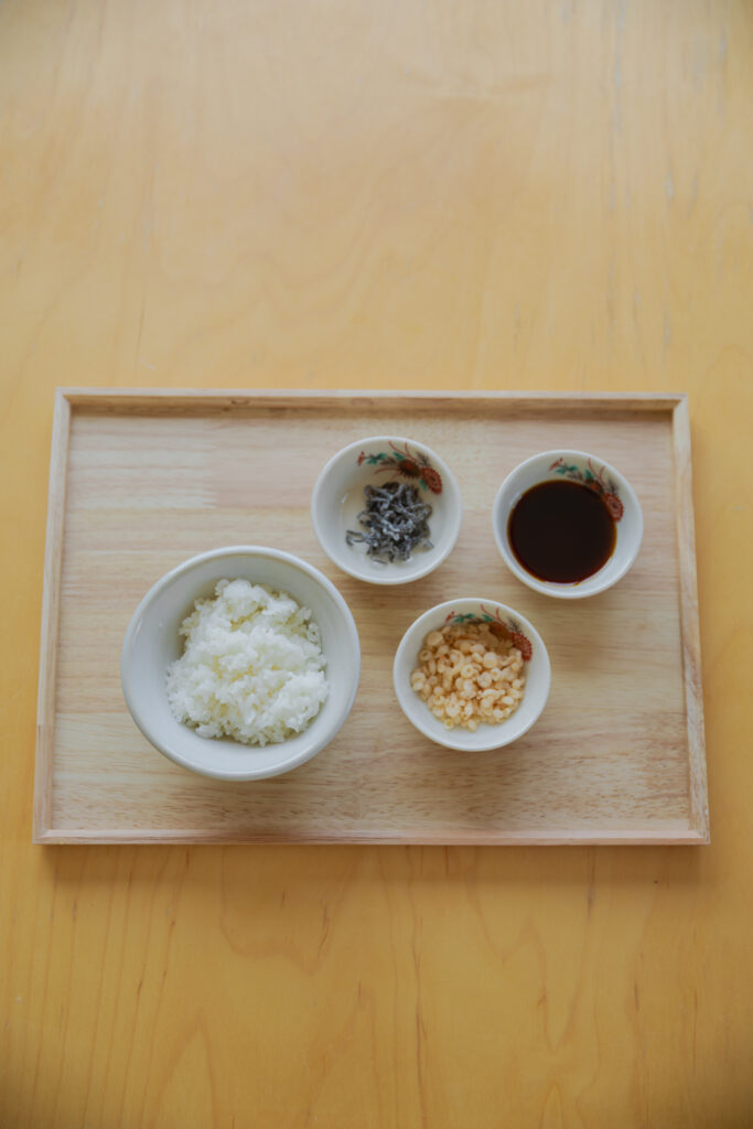 Four types of Japanese onigiri rice balls including salmon and tuna mayo on a bamboo basket