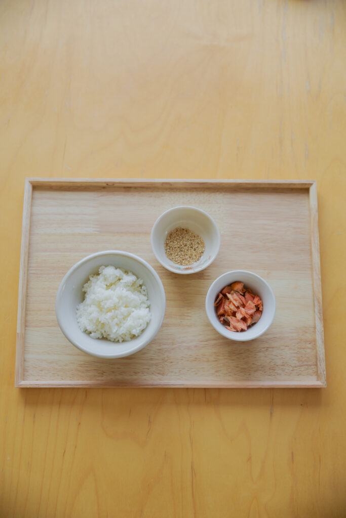 Four types of Japanese onigiri rice balls including salmon and tuna mayo on a bamboo basket