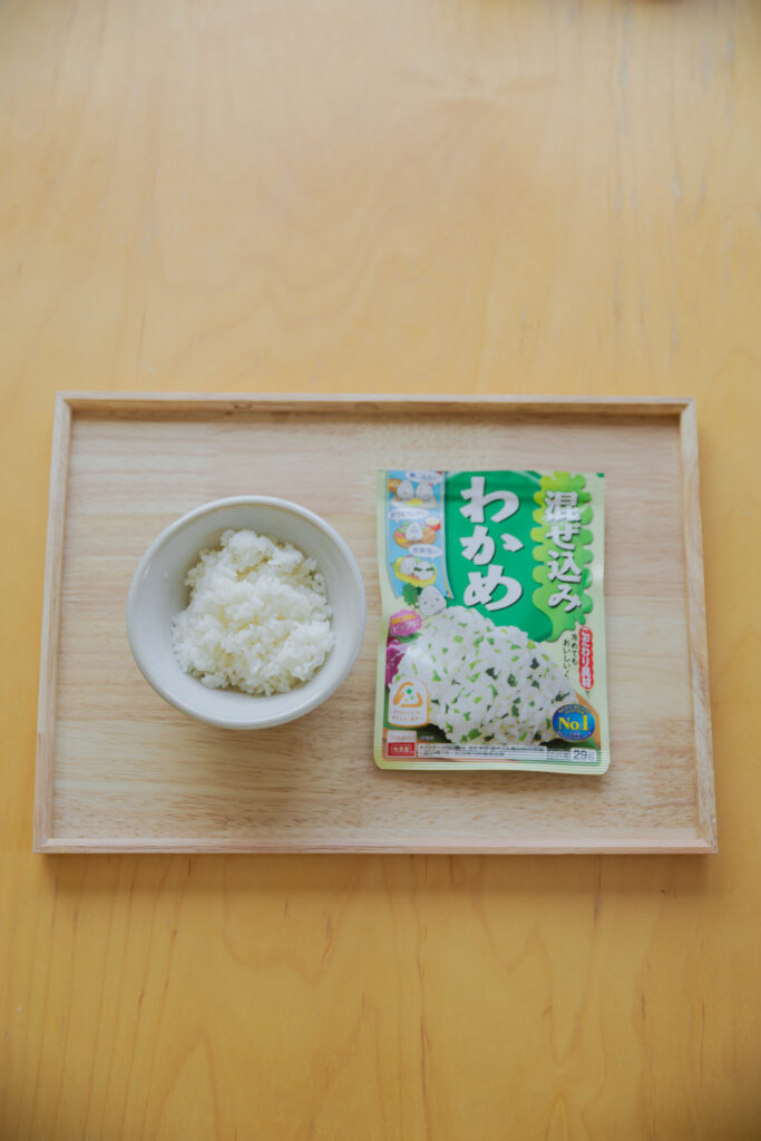 Four types of Japanese onigiri rice balls including salmon and tuna mayo on a bamboo basket