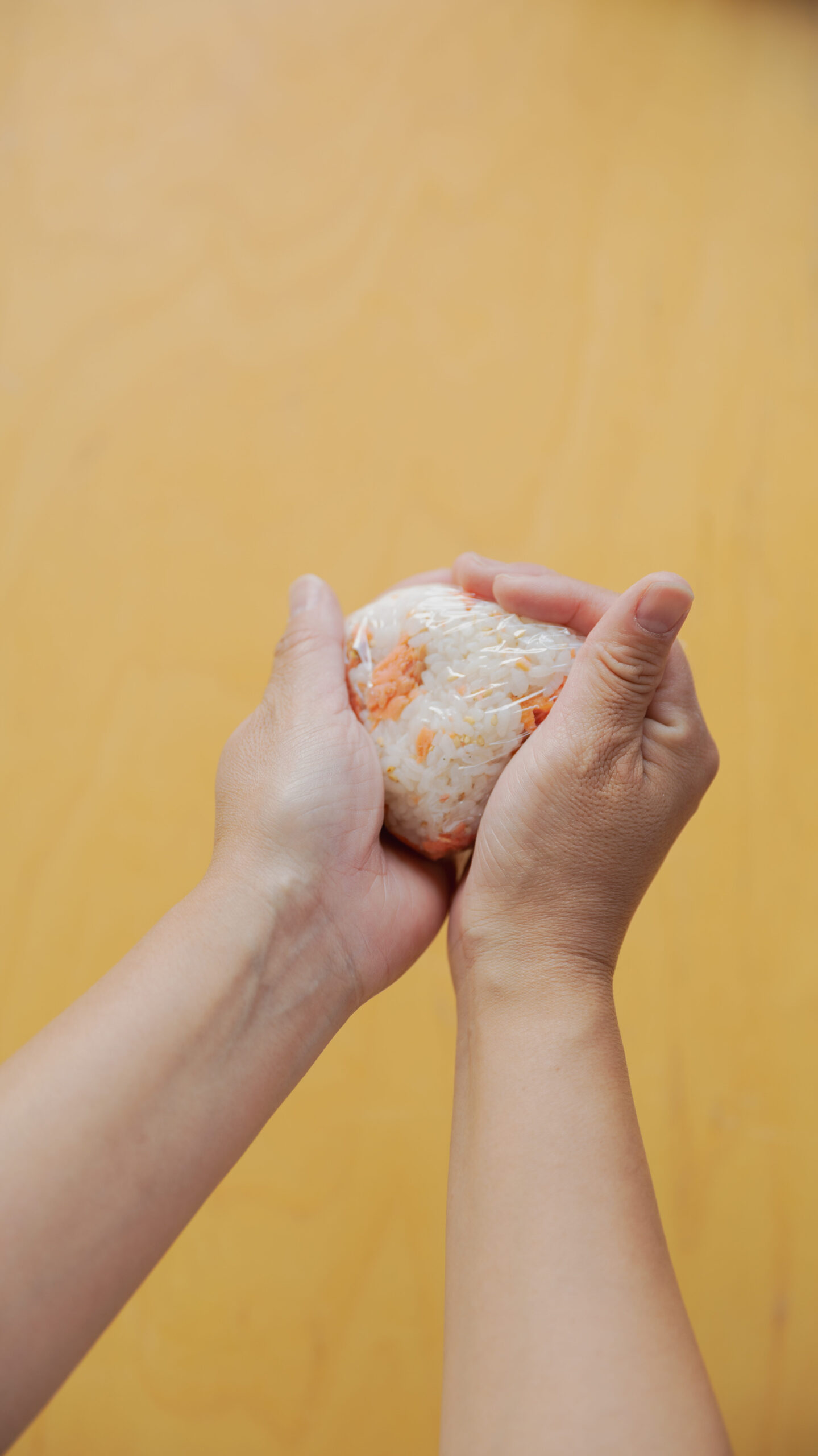 Four types of Japanese onigiri rice balls including salmon and tuna mayo on a bamboo basket