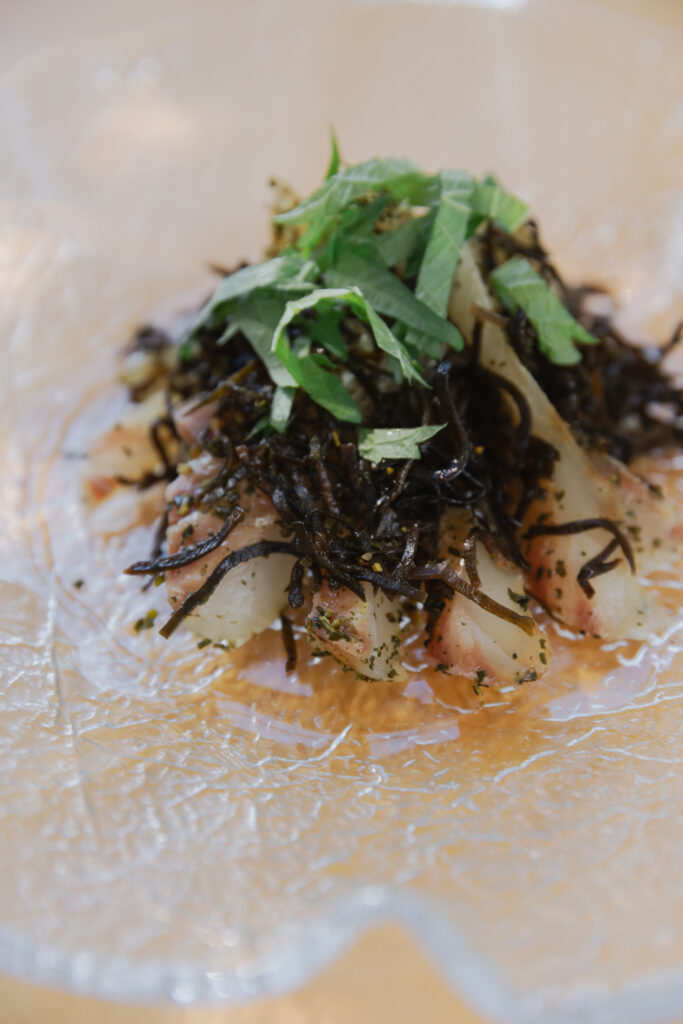 Homemade Japanese kobujime sliced fresh sea bream cured with shio-kombu on a plate