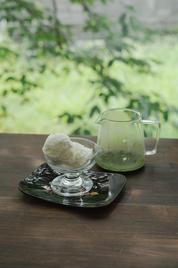 Cafe-style Japanese matcha affogato dessert with rich green matcha poured over vanilla ice cream in a glass bowl
