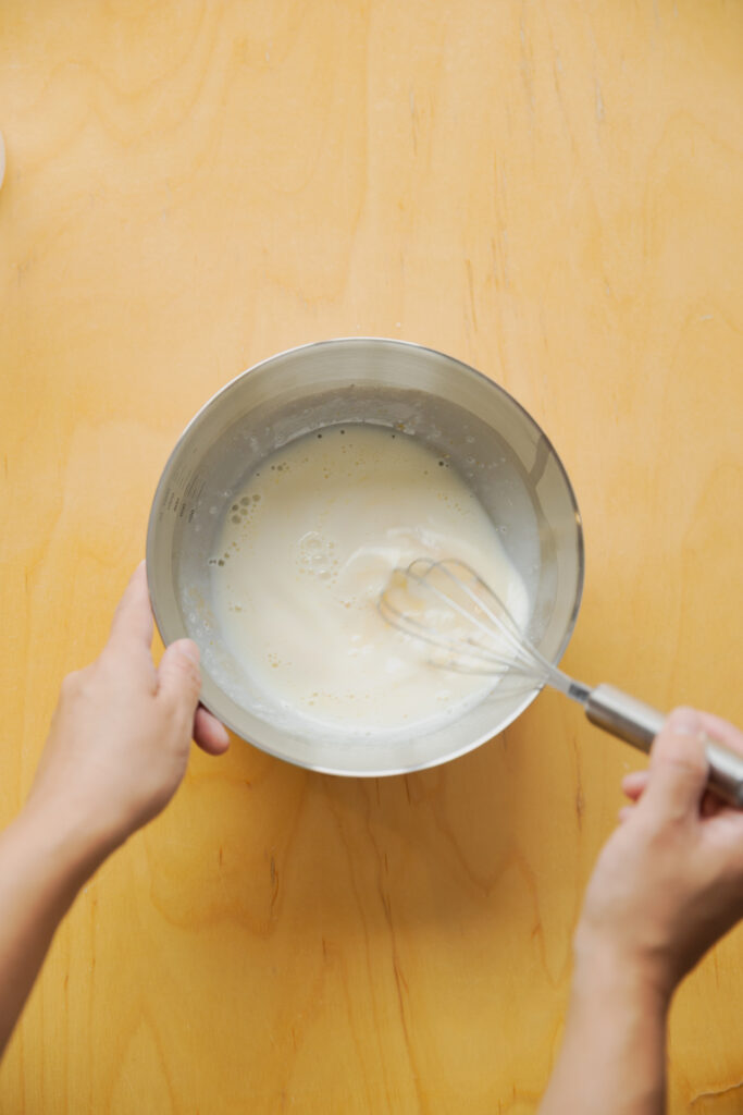 Whisking egg and milk smoothly in a bowl to make retro cafe style Japanese purin