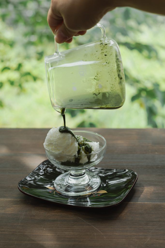 Cafe-style Japanese matcha affogato dessert with rich green matcha poured over vanilla ice cream in a glass bowl