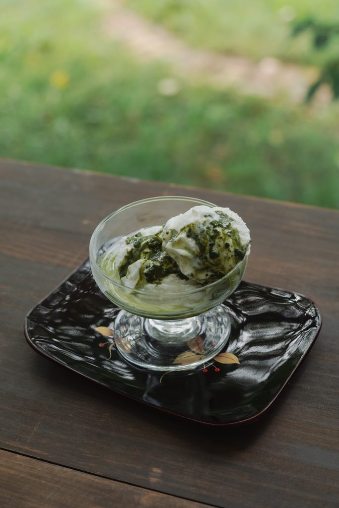 Cafe-style Japanese matcha affogato dessert with rich green matcha poured over vanilla ice cream in a glass bowl