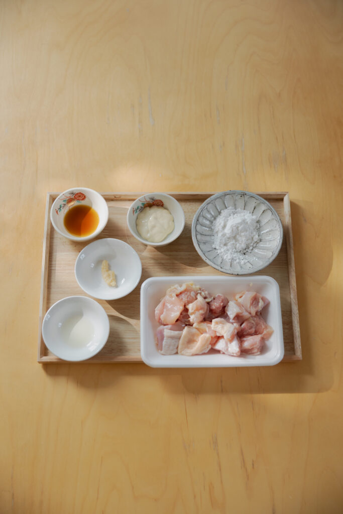 Crispy golden Japanese Karaage fried chicken served in a ceramic bowl with cherry tomatoes
