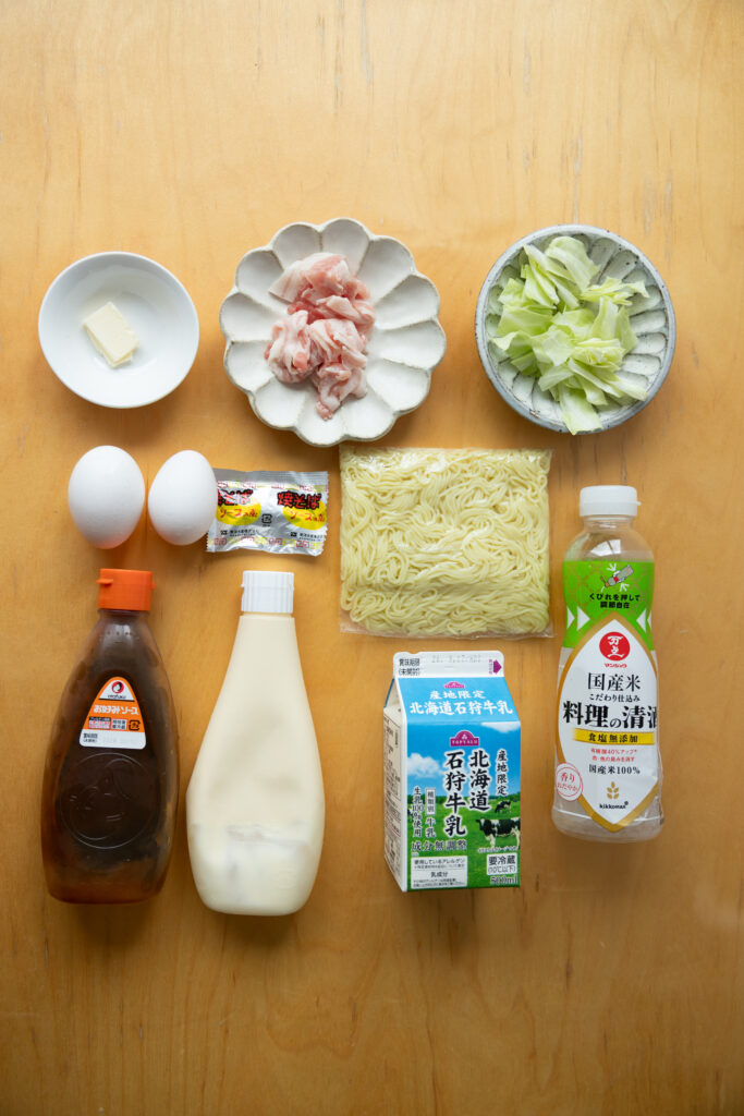 Omu-Yakisoba under perfect lighting showing rich mayonnaise lattices and green seaweed flakes