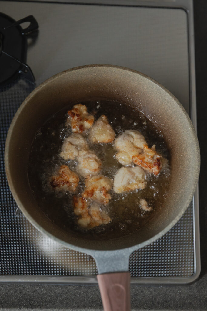 Crispy golden Japanese Karaage fried chicken served in a ceramic bowl with cherry tomatoes