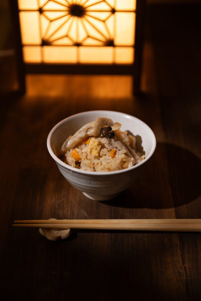 Japanese chicken mushroom rice with carrots under beautiful warm spotlight