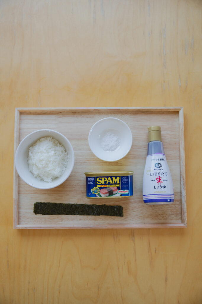 A can of Spam, a sliced piece of pork, and premium nori seaweed sheets