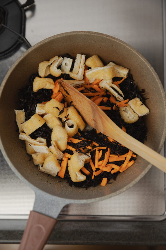 Stir-frying ingredients for Japanese Hijiki seaweed salad in a pan