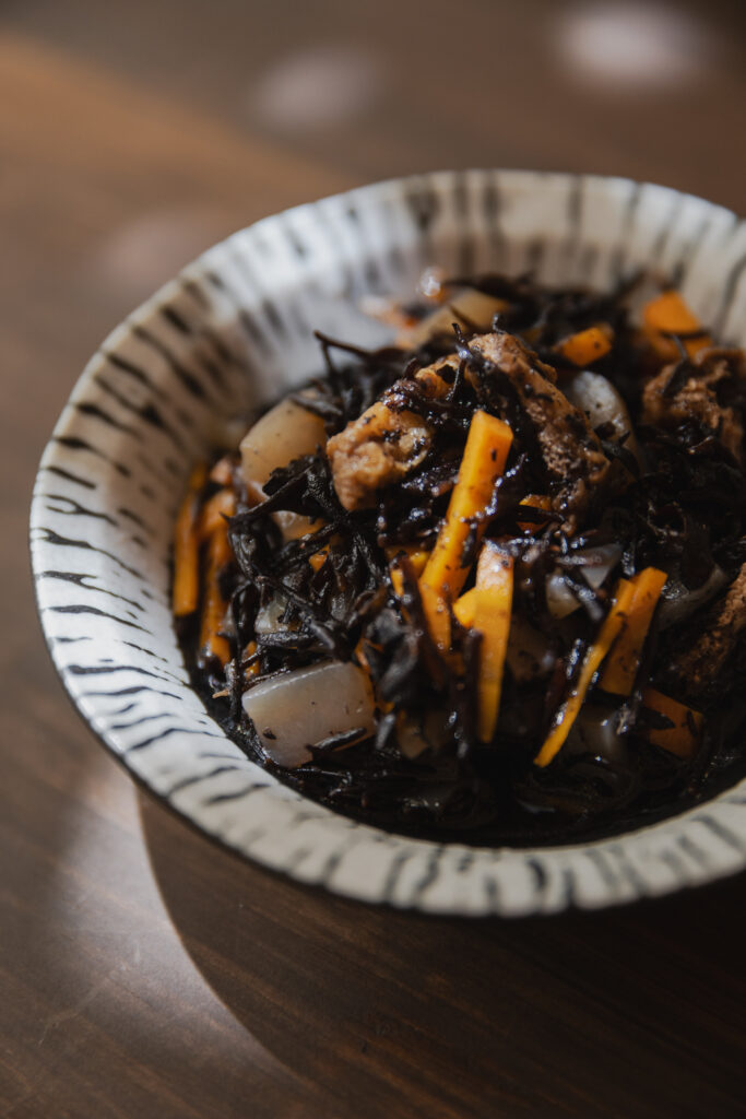 Authentic Japanese Hijiki Seaweed Salad with carrots and fried tofu in a ceramic bowl