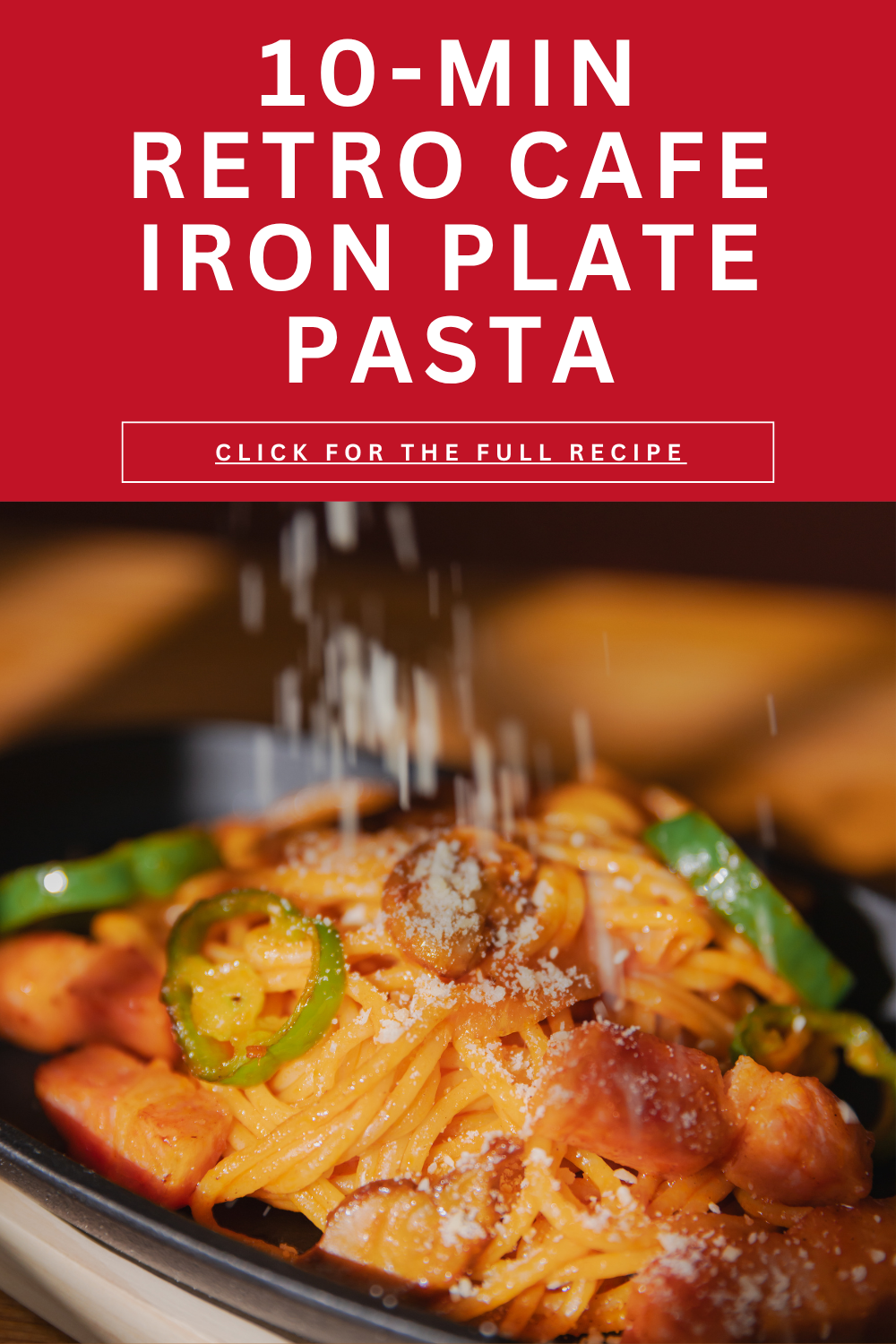 Shaking powdered parmesan cheese like falling snow over hot Japanese Napolitan pasta on a sizzling iron plate